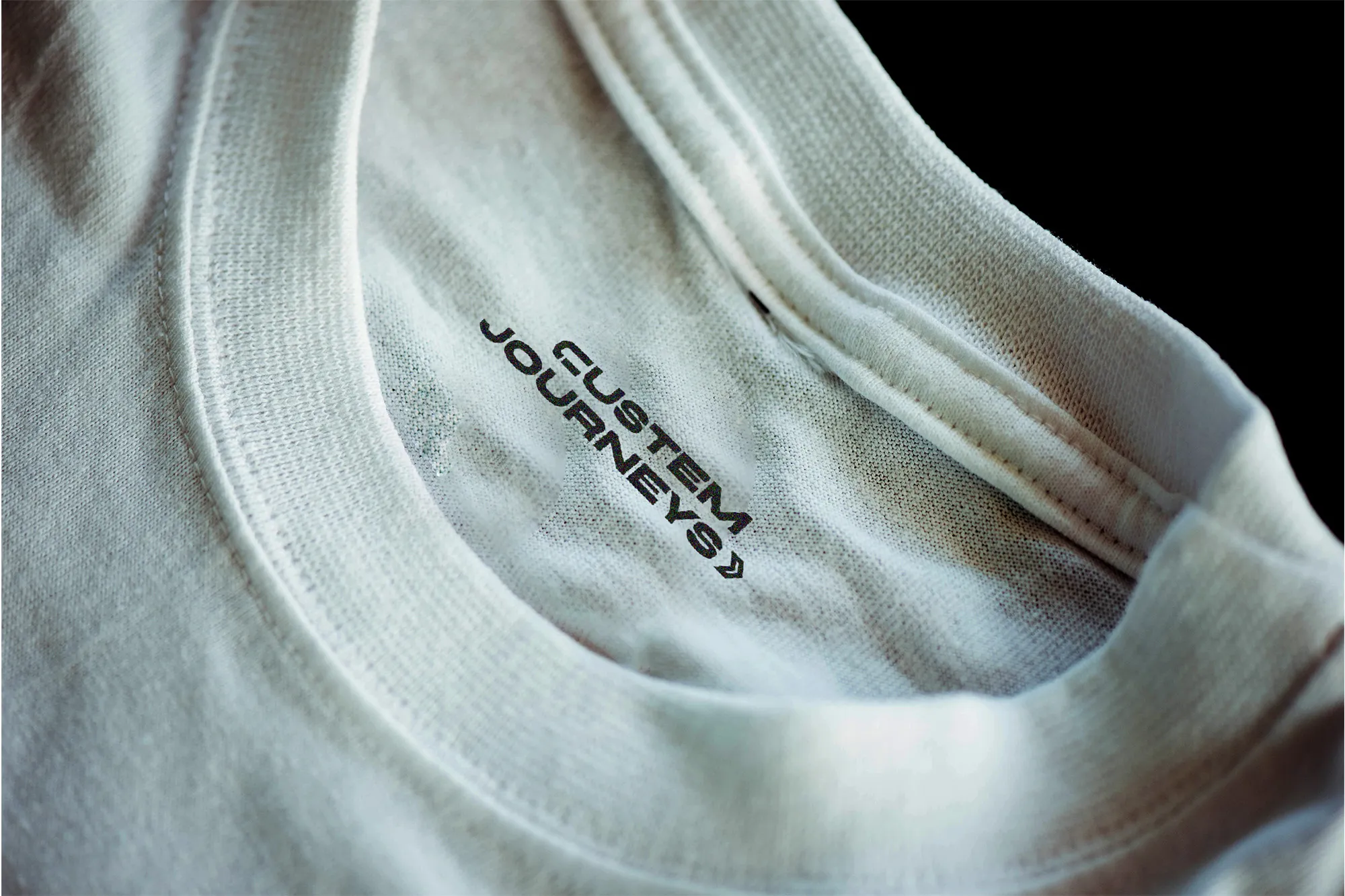 Closeup of the inside collar of a t-shirt featuring the cuSTEM Journeys secondary logo design